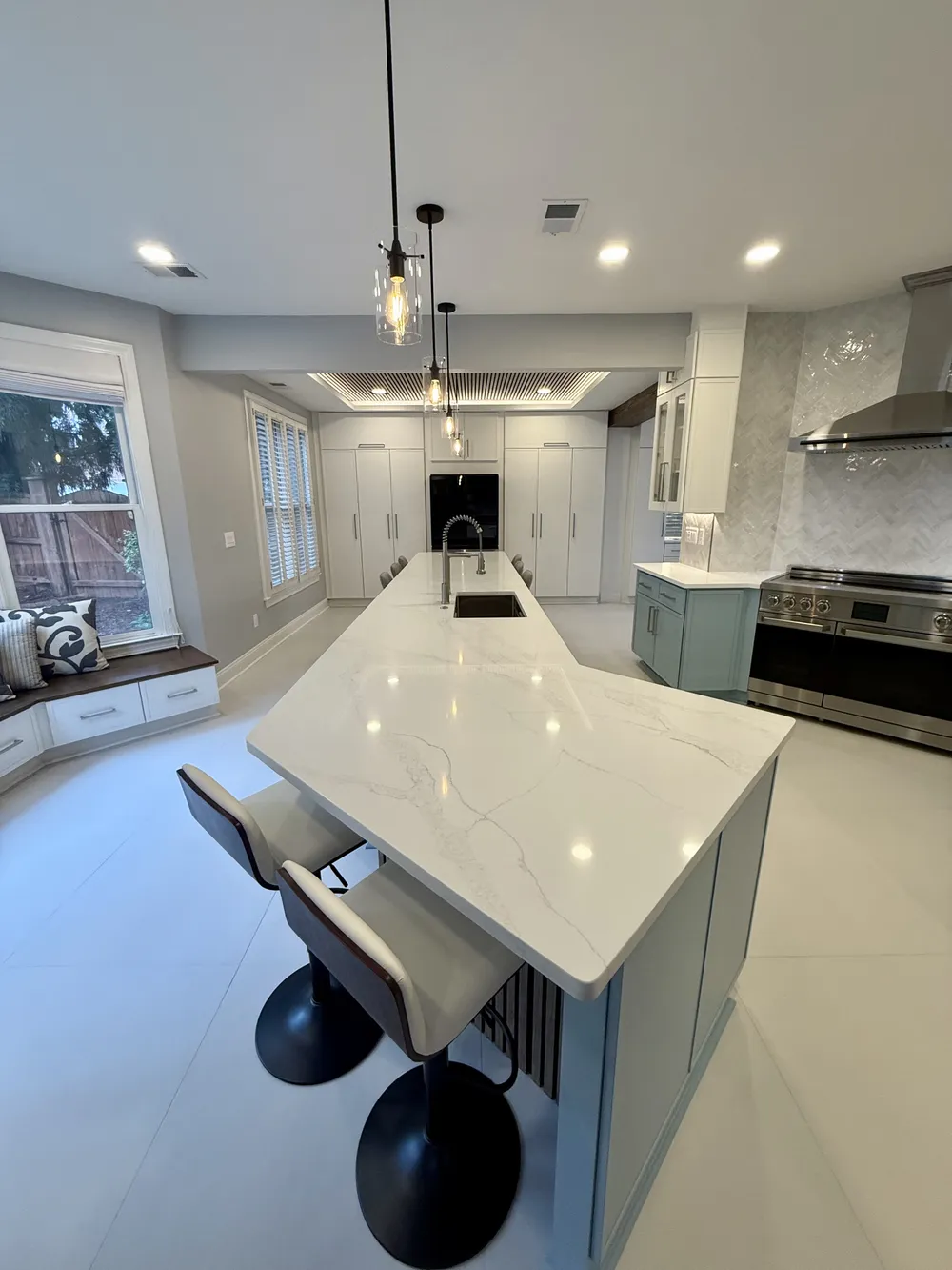 Custom light blue shaker cabinets with detailed hardware, finished by Anchor & Grain.